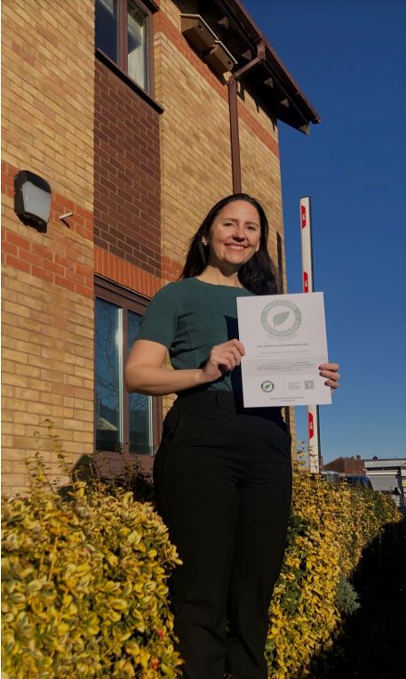 Emma Danielsson, the councils climate change officer holds the silver certificate. Behind her are swift boxes which have been installed as part of the council's work to protect nature 