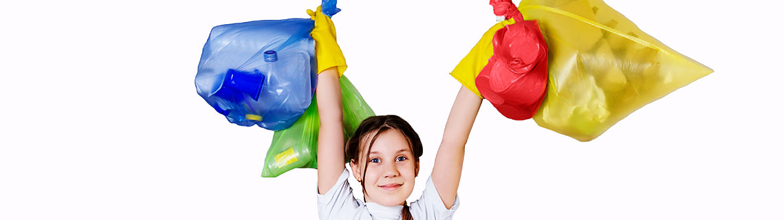 girl smiling holding multi-coloured bags with sorted rubbish in 