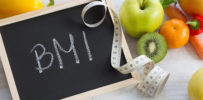 chalkboard with BMI written on it with a tape measure and fruit surrounding it